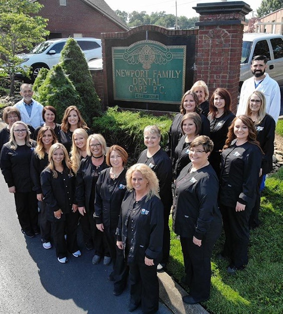 Newport Family Dental Care team standing by their business sign