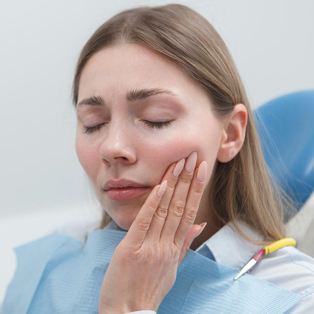 Dental patient holding jaw in pain