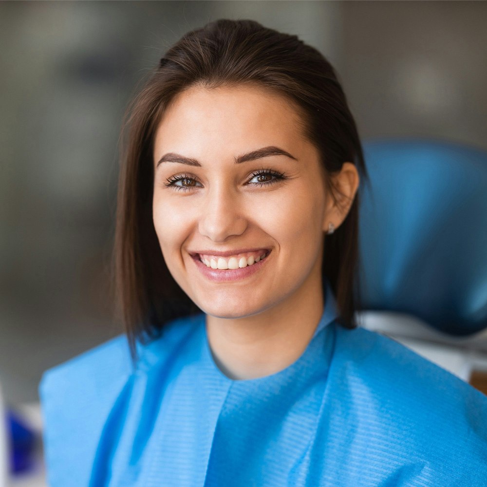 Set of sample porcelain veneers held up to patient's teeth for color-matching