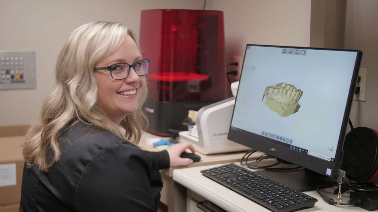 staff member looking at dental arch on computer