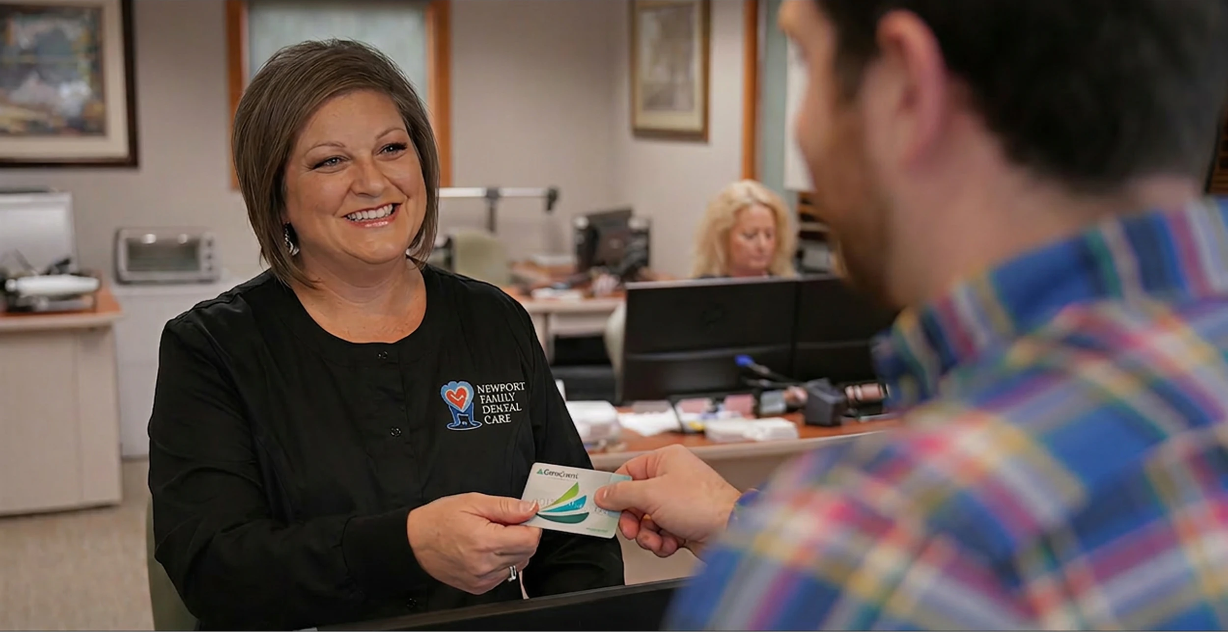 man handing his CareCredit card to a staff member