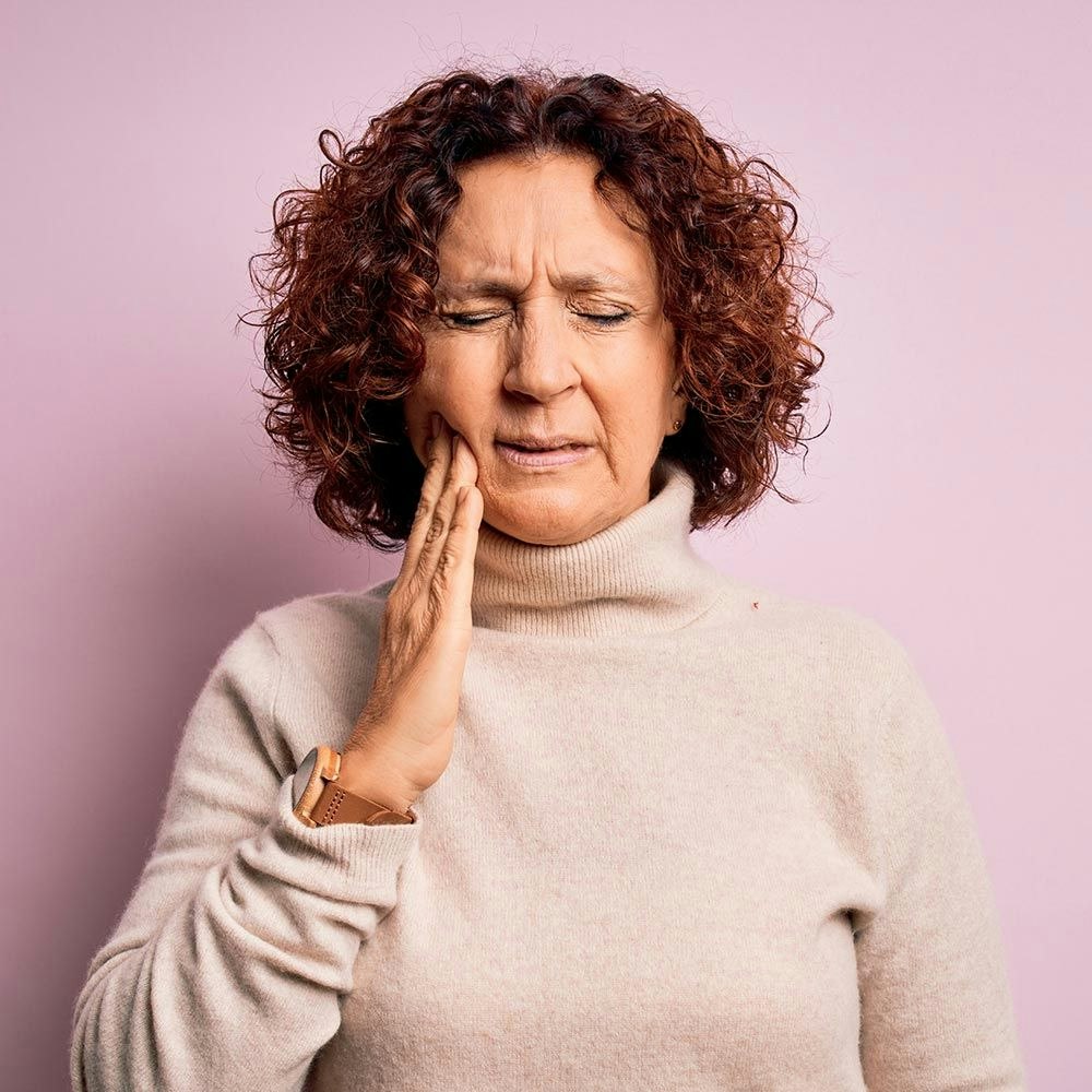 Older woman holding mouth in pain