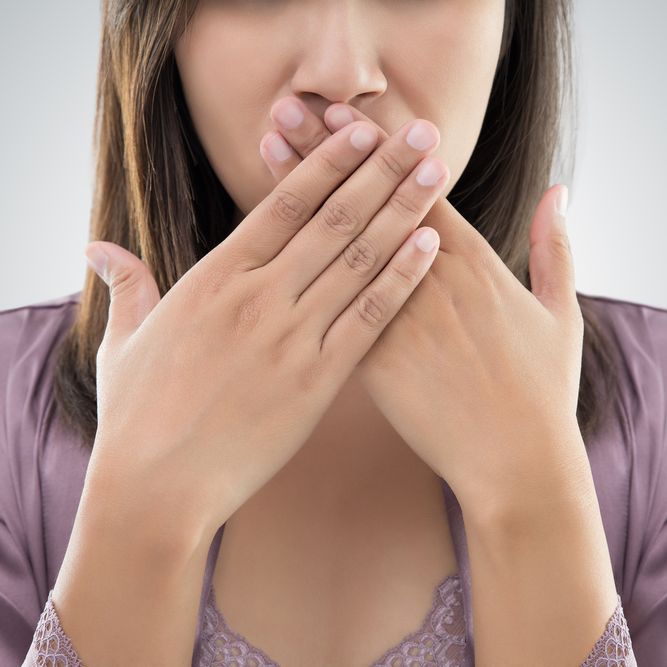 Embarrassed woman covering mouth