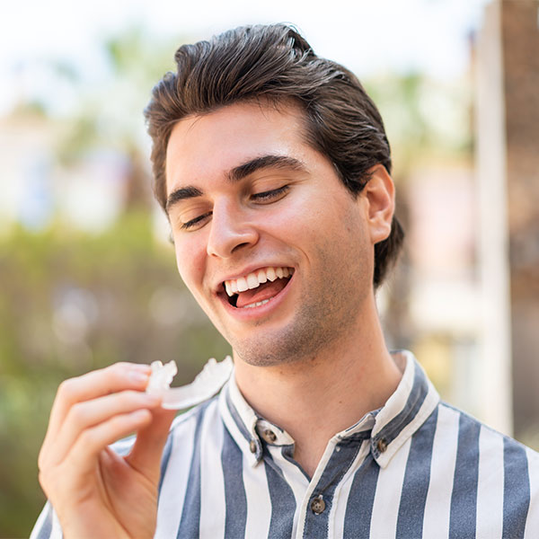 man looking at an invisalign aligner