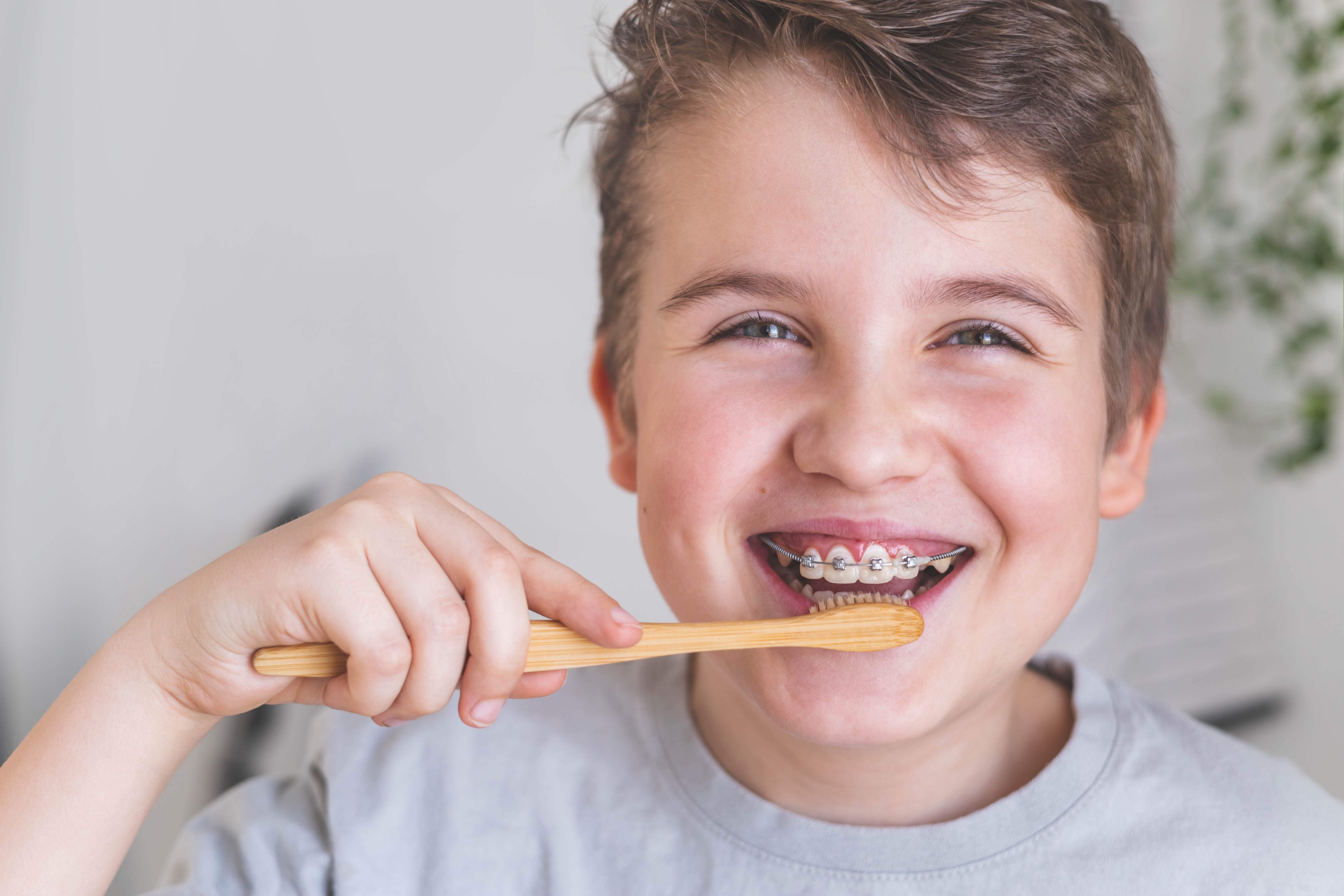 Boy with braces brushing his teeth