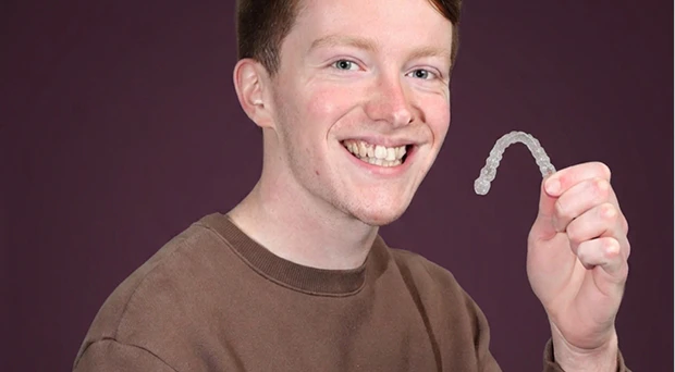 patient holding Invisalign aligner