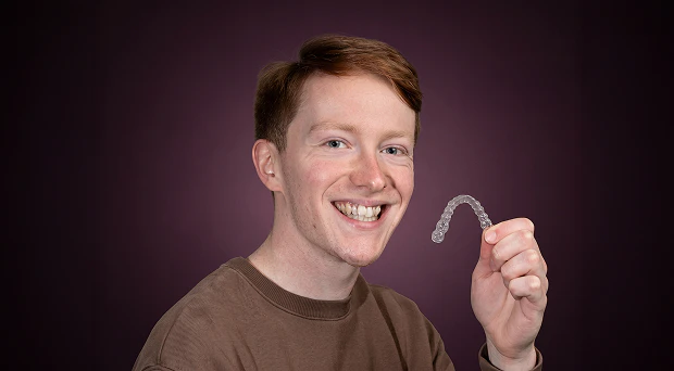 man holding invisalign tray