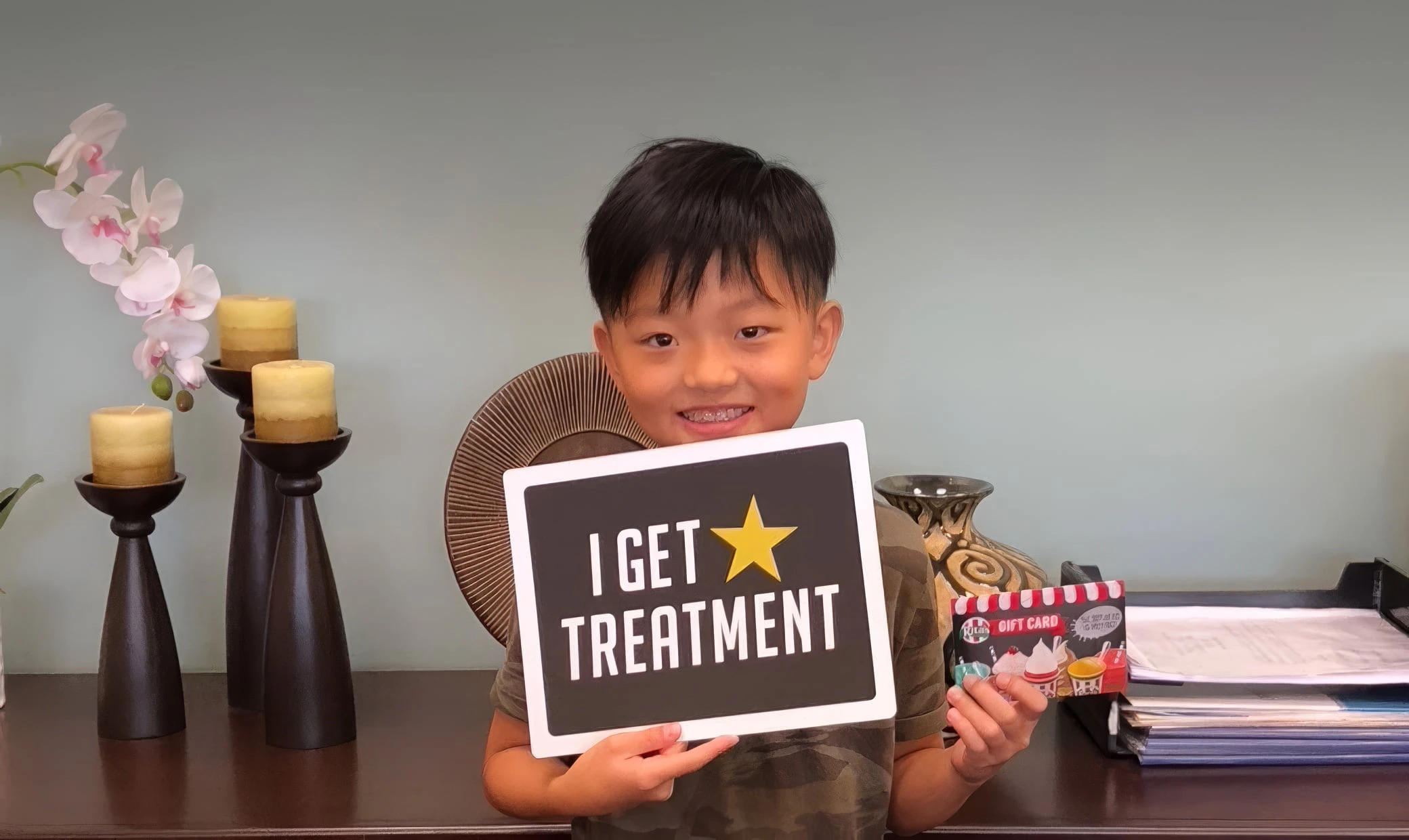 young orthodontis patient holding a sign that says, 