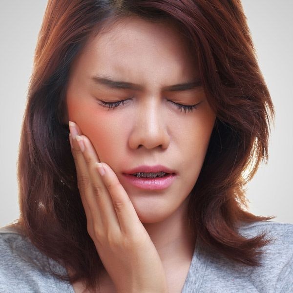 woman holding her face in pain