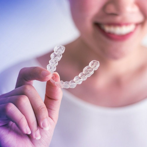 a hand holding Invisalign appliance