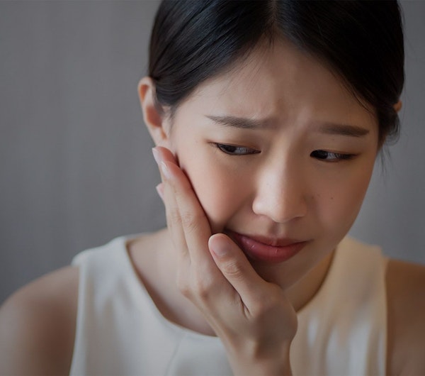 Girl gripping jaw in pain