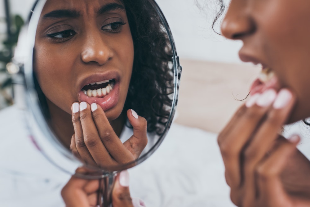 Woman examining teeth in the mirror