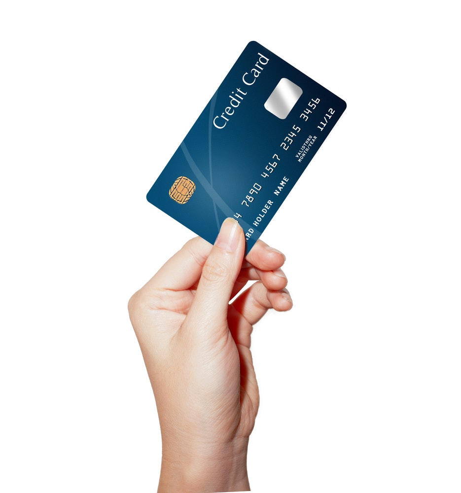 A hand holding a credit card with a solid white background.