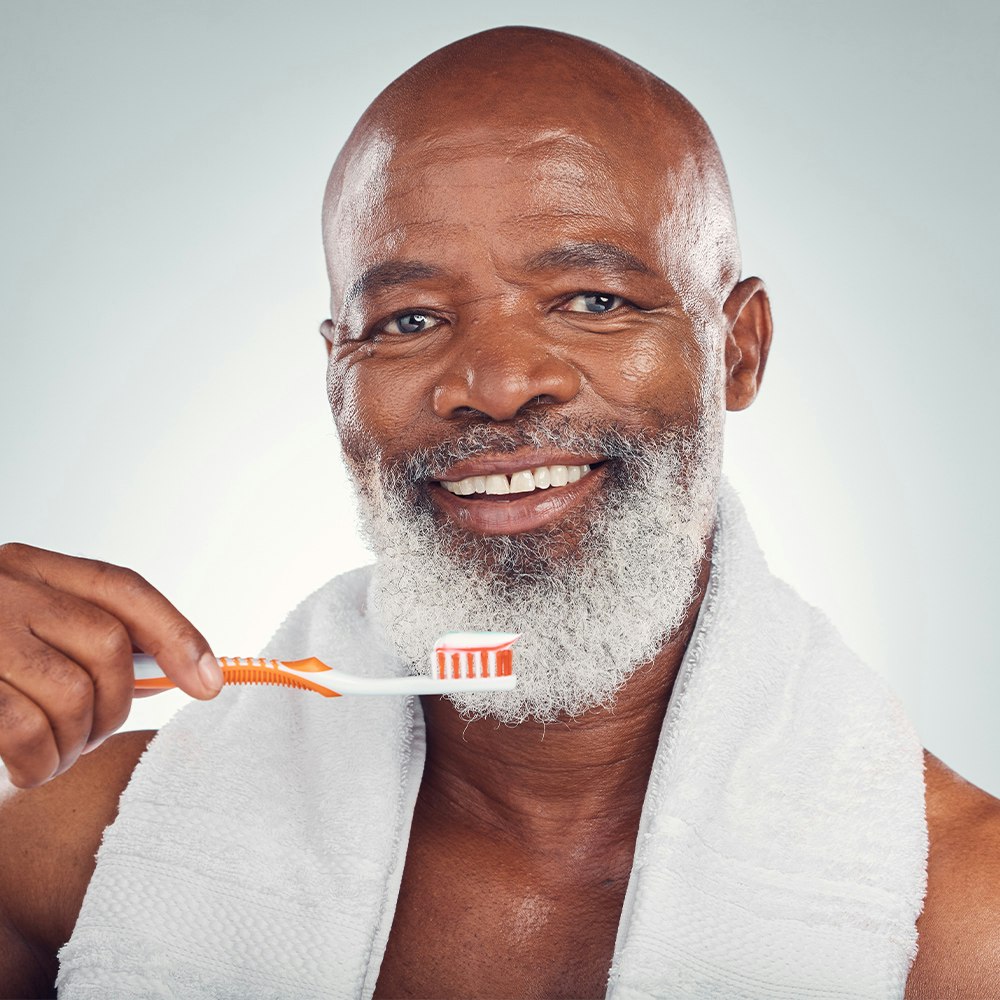 Older man brushing his teeth
