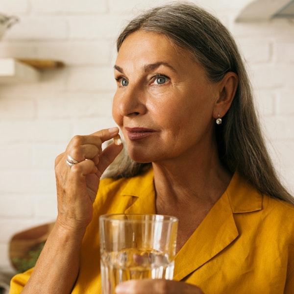 Woman taking pain medication after a root canal