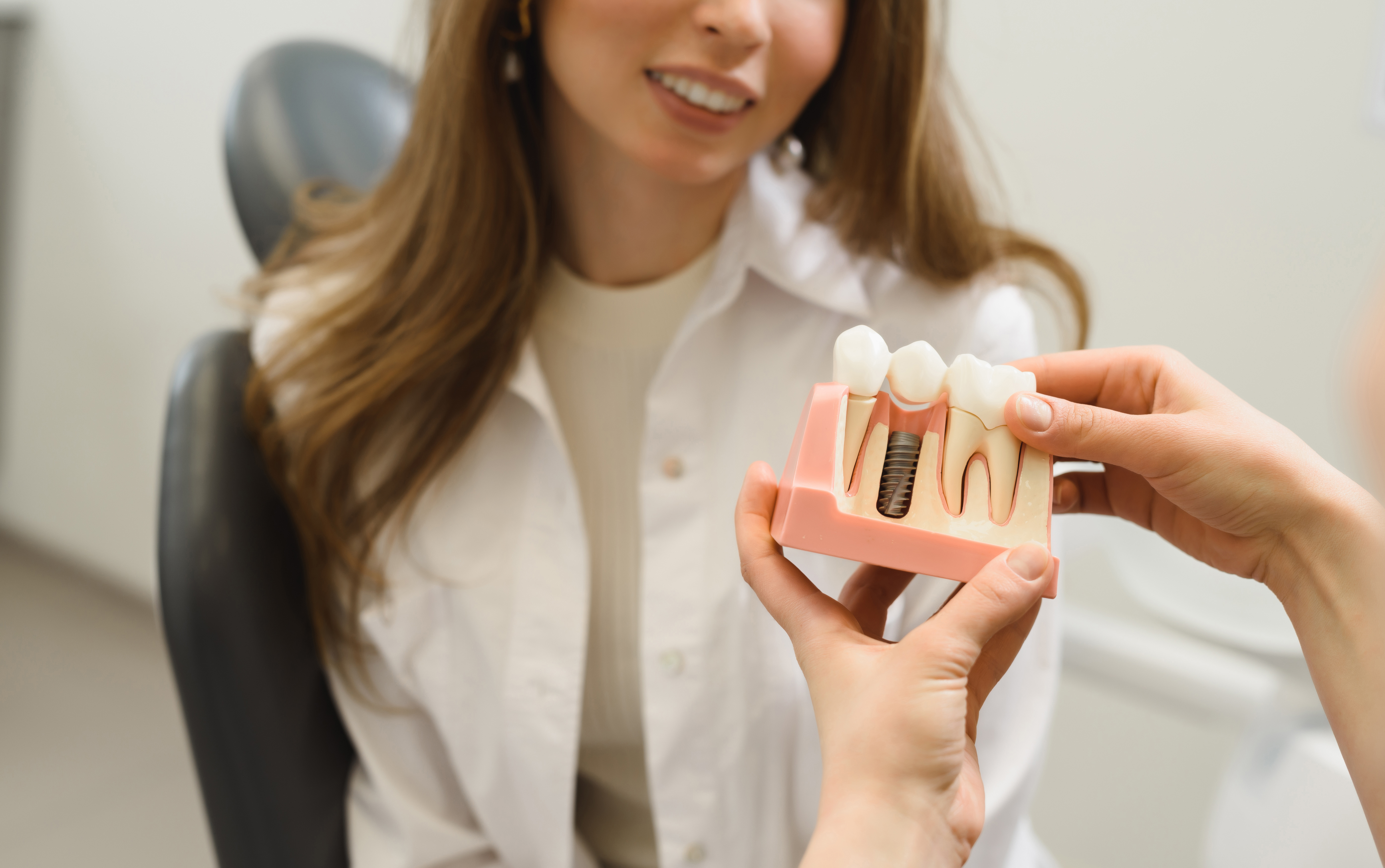 Dentist showing patient dental implant model