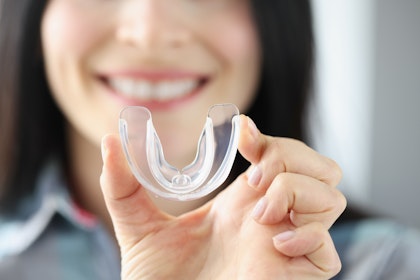 woman holding mouth guard
