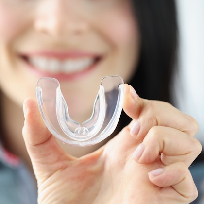 woman holding mouth guard