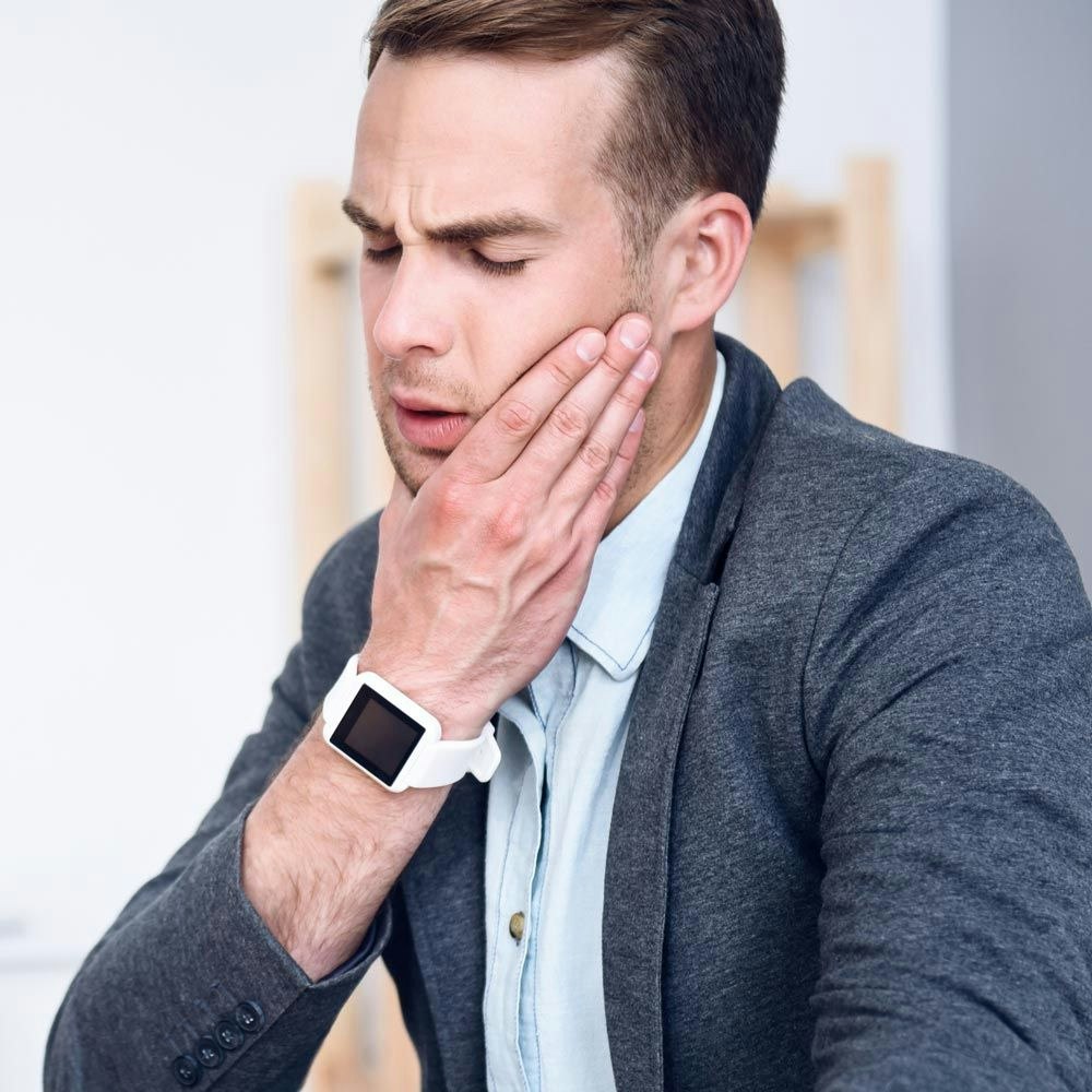 Man holding jaw in pain