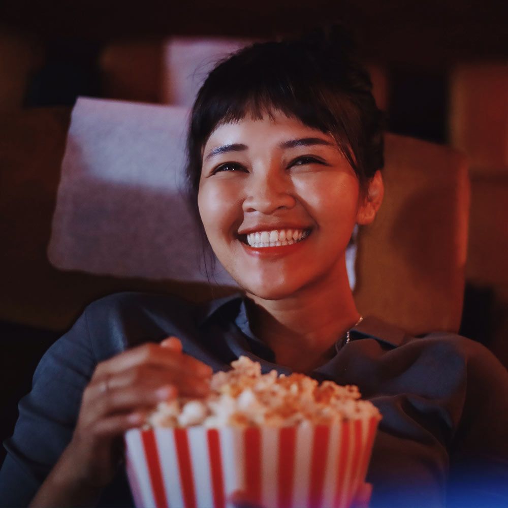 Woman smiling and eating popcorn