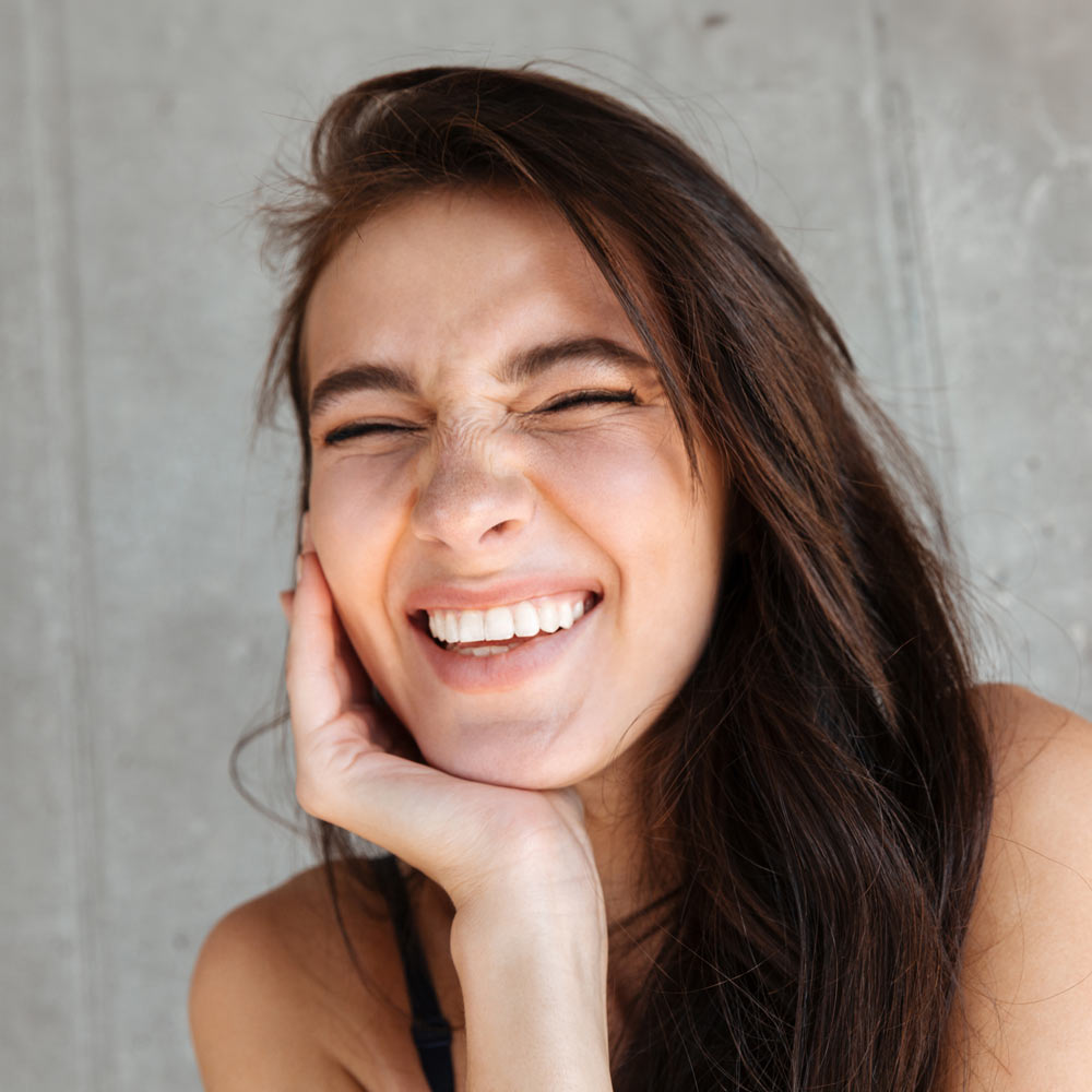 Young woman leaning on hand and smiling
