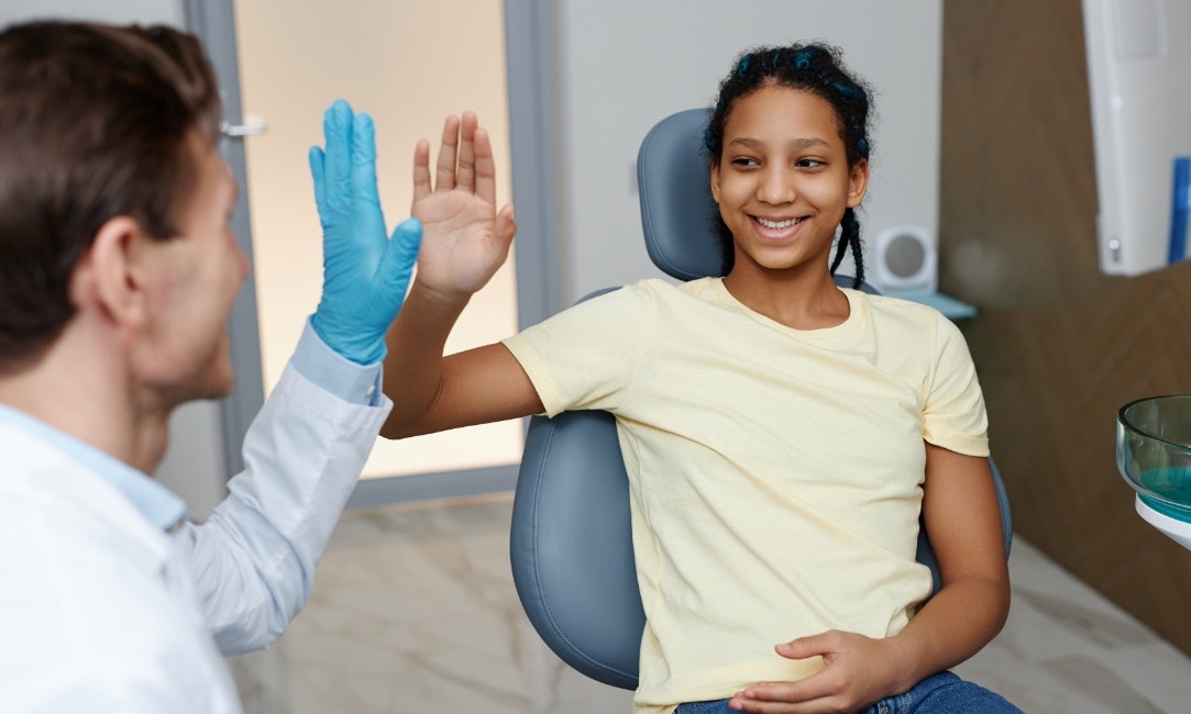 Young invisalign patient high fiving dentist