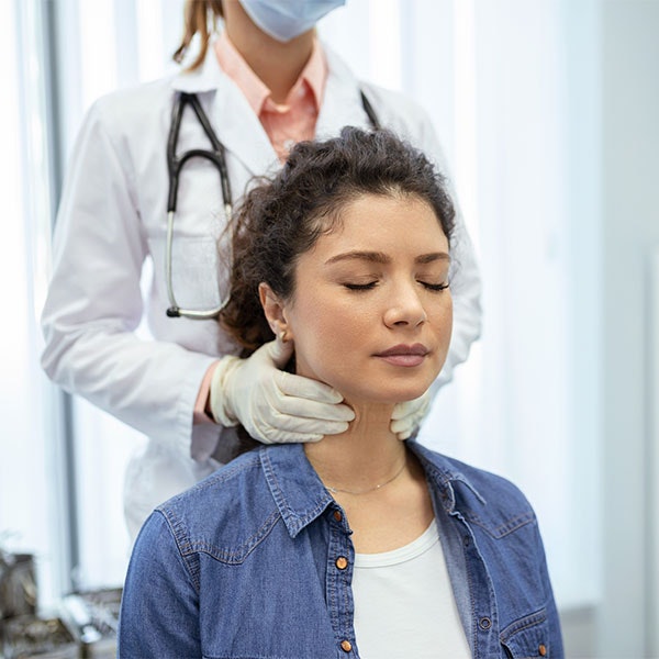 Young woman getting her neck examined by a doctor after a car accident