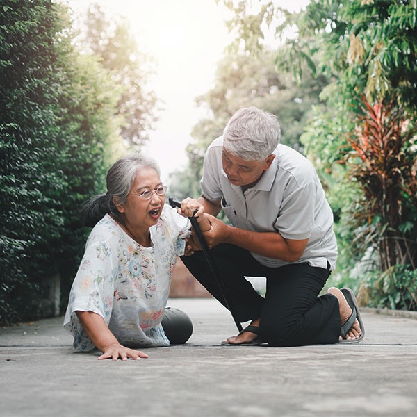 Man helping a senior woman after she fell on public property