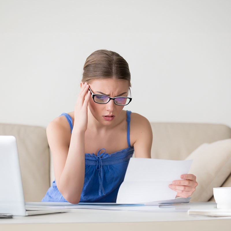 overwhelmed woman looking at bills