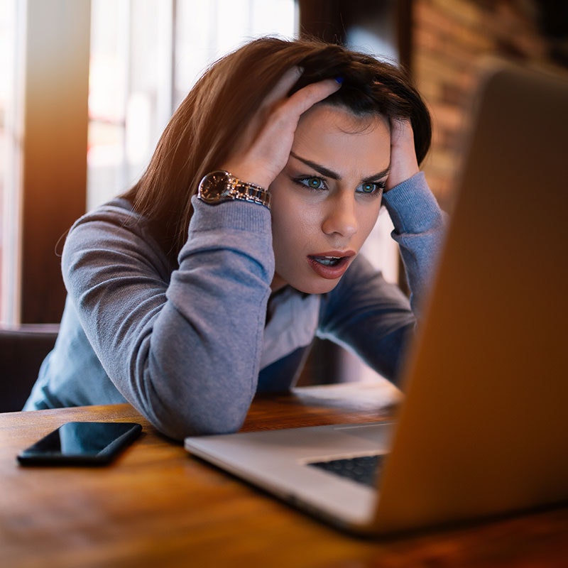Woman looking at a computer stressed