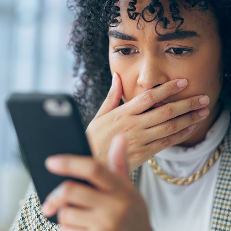 Woman looking at her phone worried