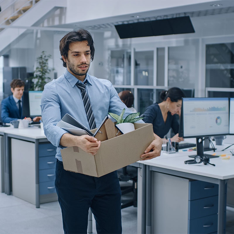 Man walking out of the office with a box full of his stuff