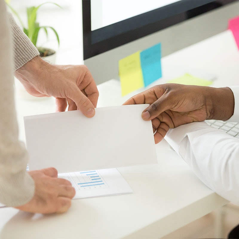 Boss handing envelope to employee