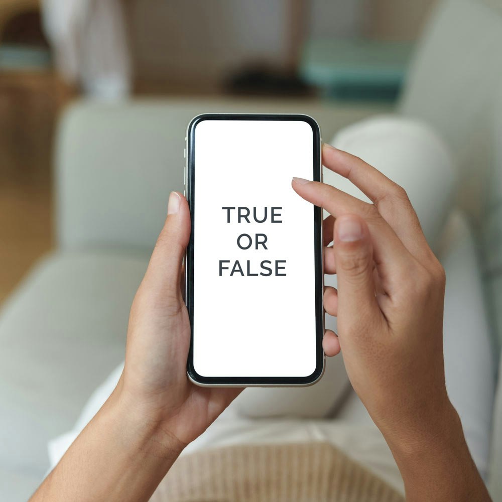 Girl holding up phone with "true or false" written on the screen