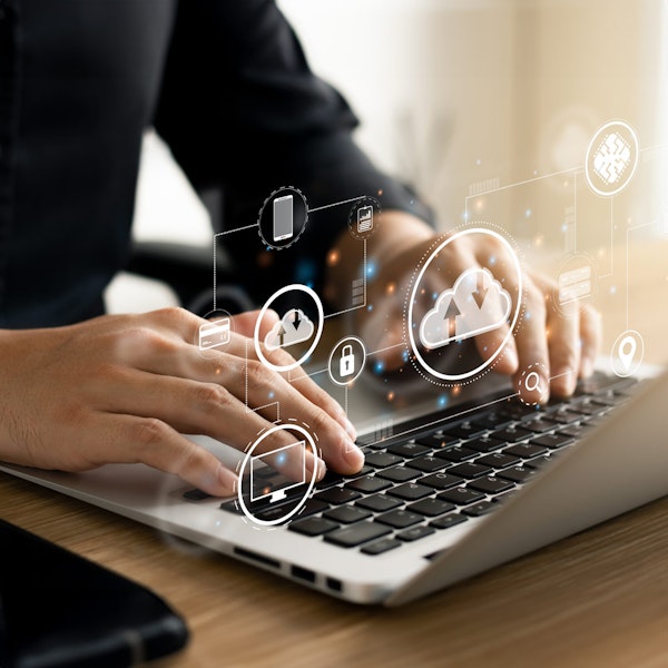 Person typing on laptop with cloud computer technology icons above