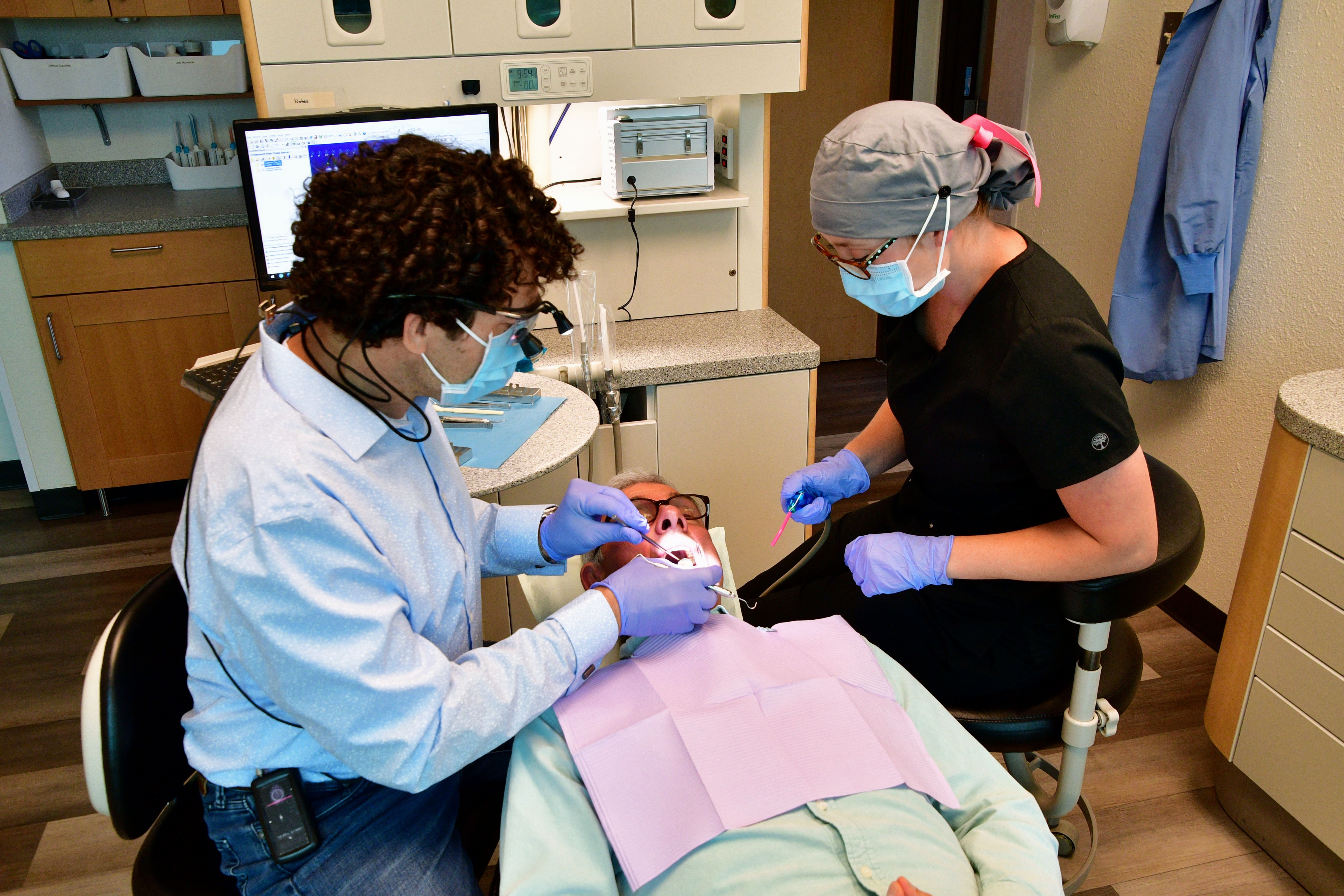 Dentist and hygienist working on a patient