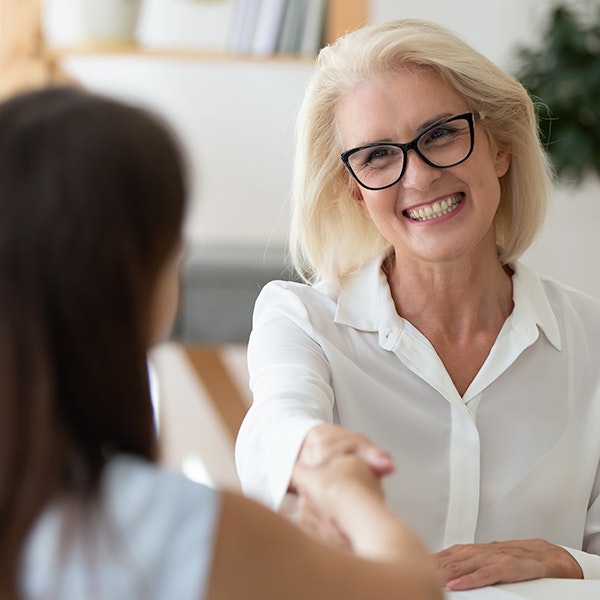 Smiling woman shaking hands with another woman