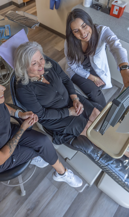 dentist showing senior woman her teeth on a monitor