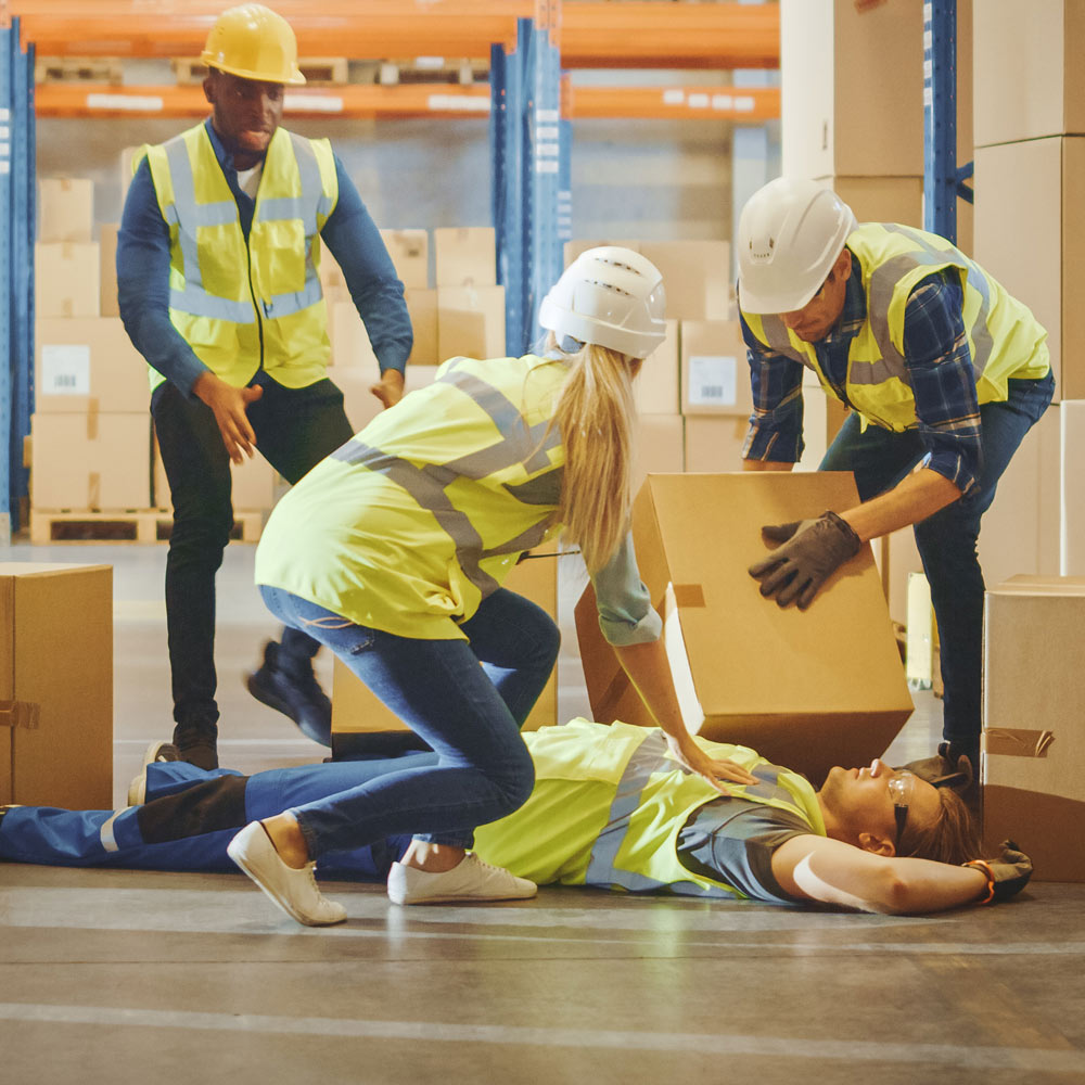 Factory workers assisting injured co-worker