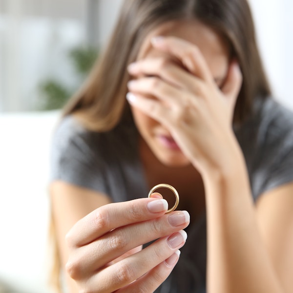 Woman crying while looking at her partner's wedding ring