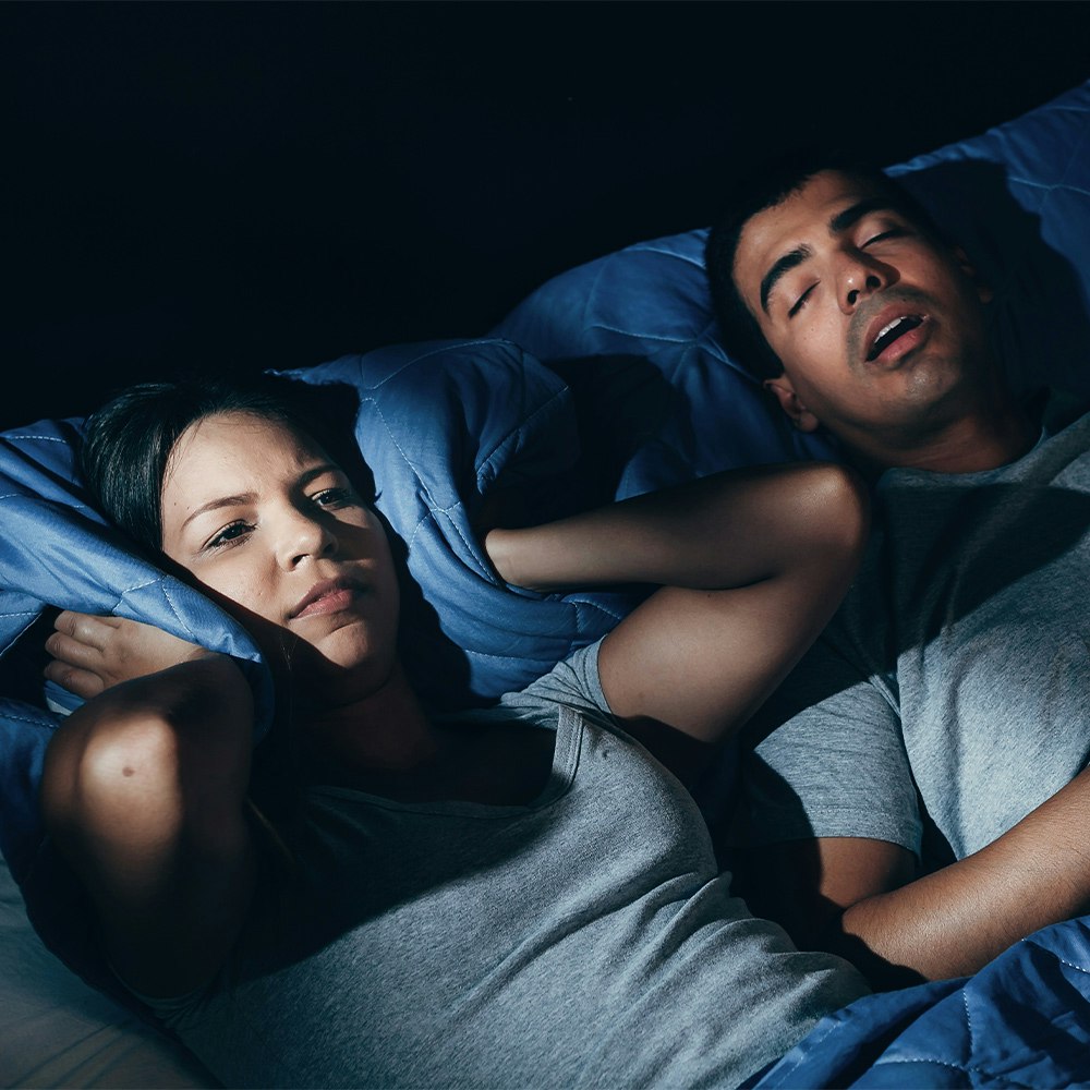 Man suffering from sleep apnea bothering his partner while sleeping