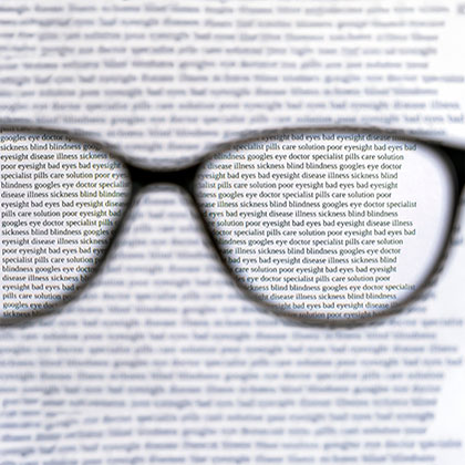Blurry book pages background with clear vision through glasses