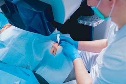 Eye doctor placing drops in patient's eyes before surgery