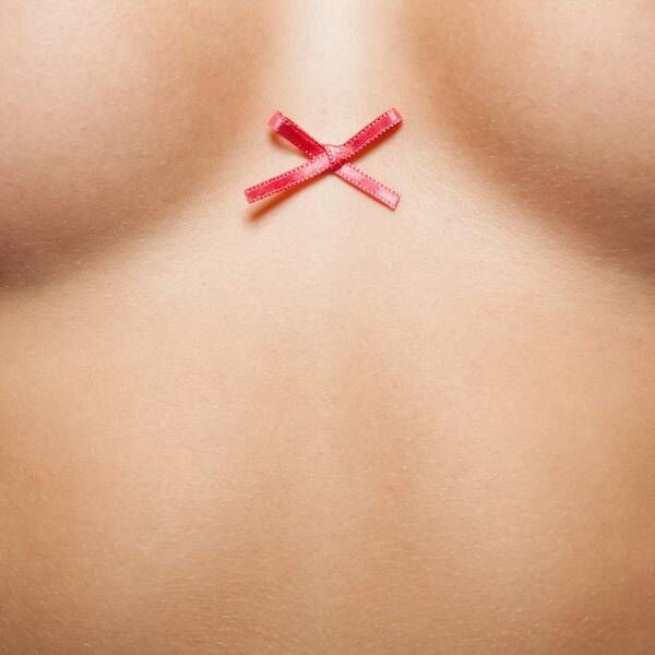 a closeup of a woman with ribbon between her breasts