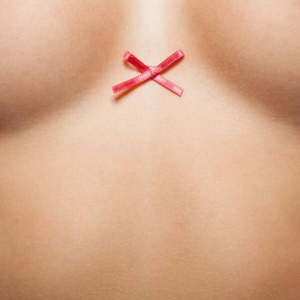 a closeup of a woman with ribbon between her breasts