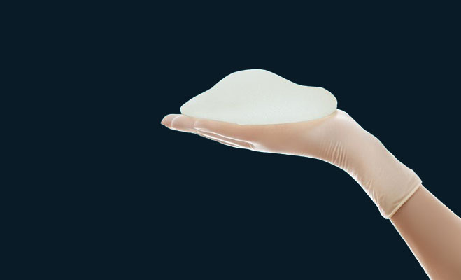 hand holding a silicone implant