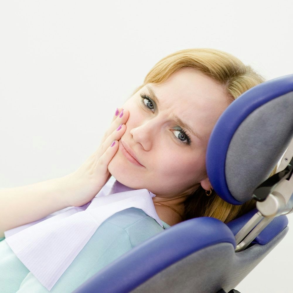 woman holding her face in pain