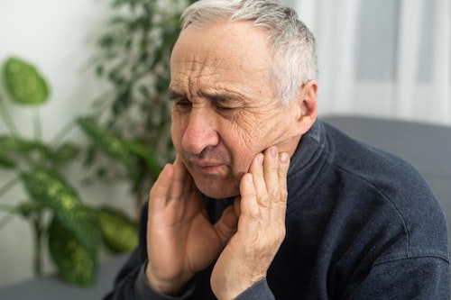 mature man holding face in pain