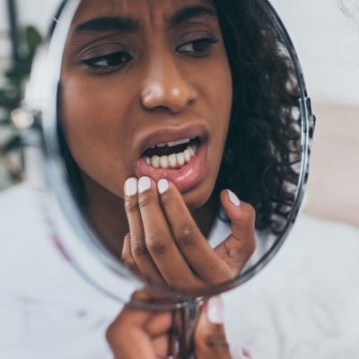 woman looking at her teeth in the mirror