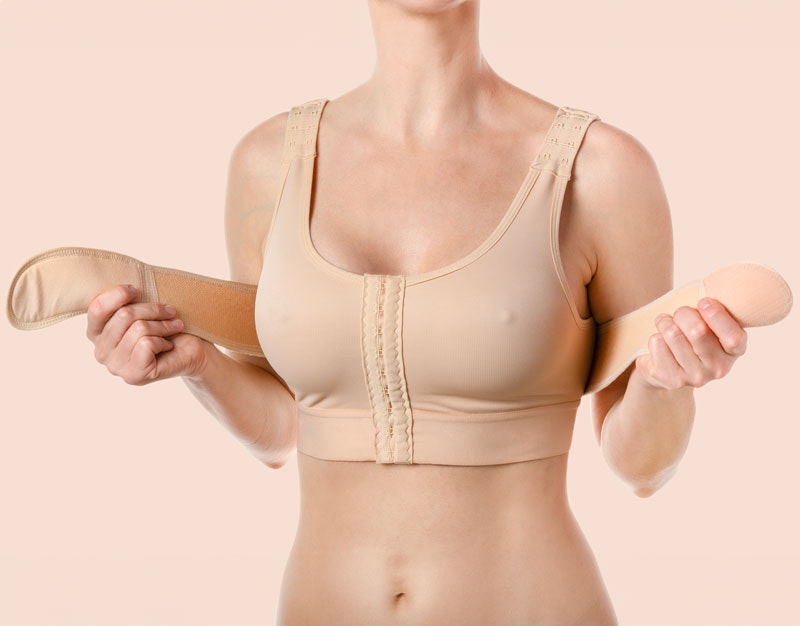 woman putting on support bra